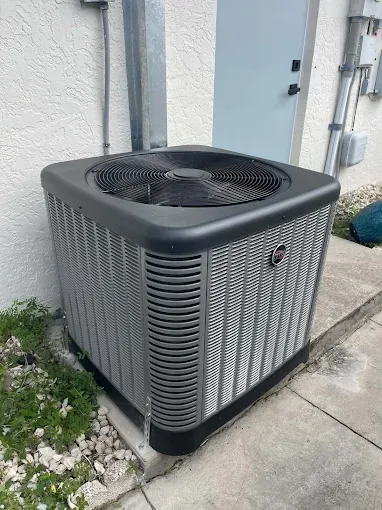 New Rheem 3-ton two-stage condenser installed on a pad beside a Port Charlotte home
